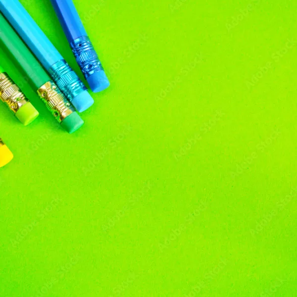 lapices de colores y gomas de borrar sobre un fondo plano de color verde espacio para escribir y componer stockpack adobe stock jpg